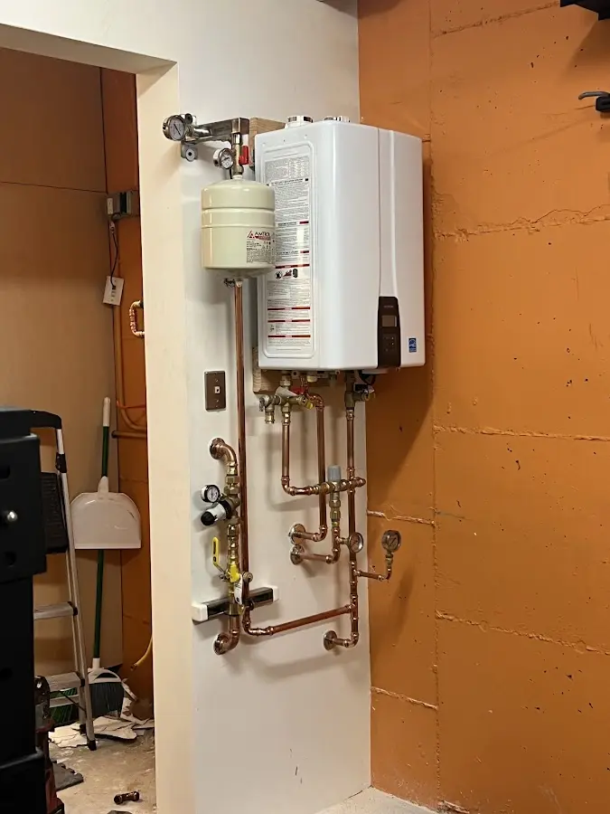 Plumbing technician inspecting water heater connections in Wooster